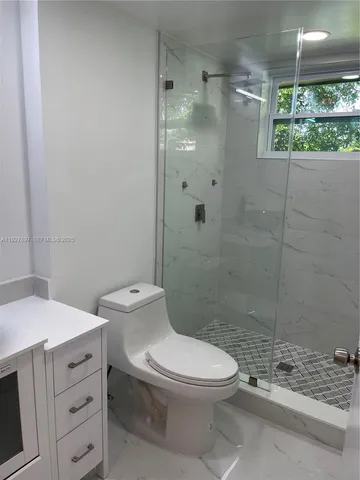 a bathroom with a toilet a sink and shower