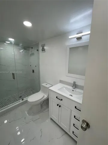 a bathroom with a double vanity sink toilet and shower
