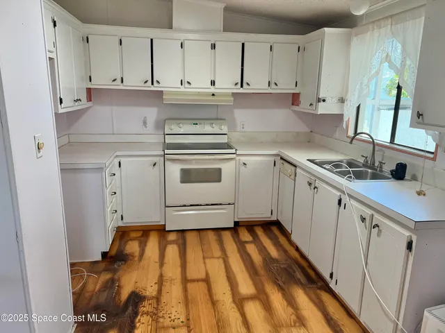 a kitchen with granite countertop white cabinets and white appliances