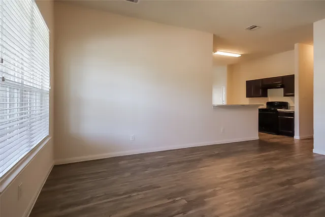 a view of a kitchen with wooden floor and electronic appliances