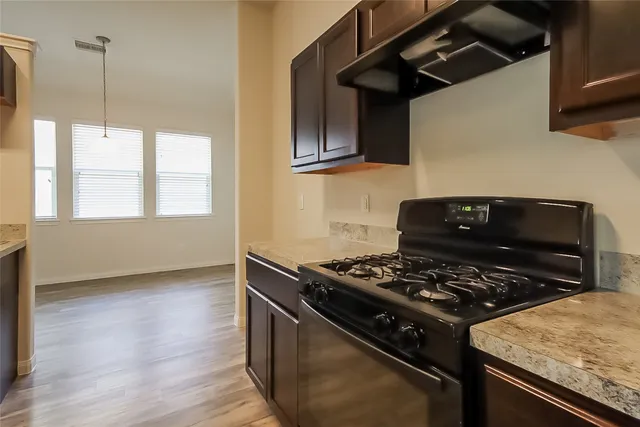 a kitchen with stainless steel appliances granite countertop a stove a sink and a microwave