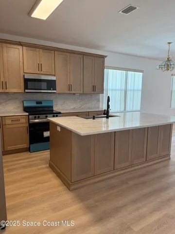 a kitchen with stainless steel appliances granite countertop a stove a sink and a microwave