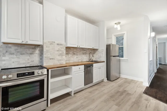 a kitchen with a refrigerator stove and white cabinets