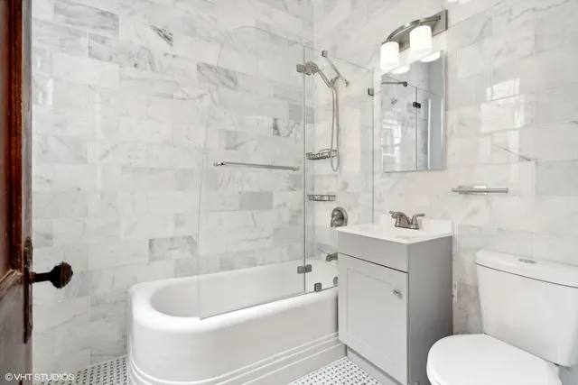 a white bath tub sitting next to a white sink and vanity