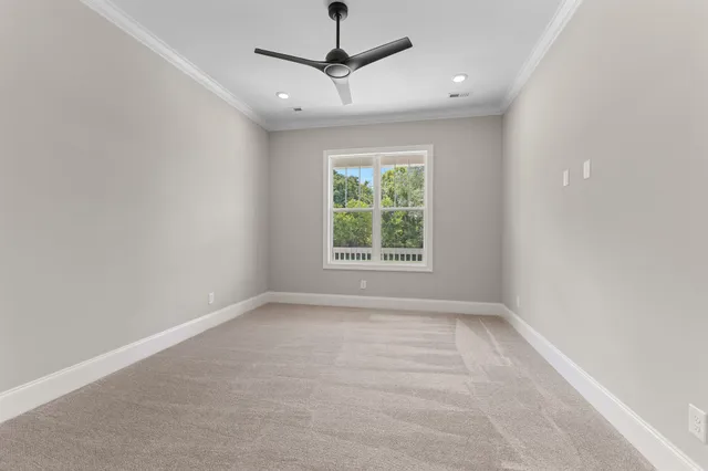 en empty room with windows and ceiling fan