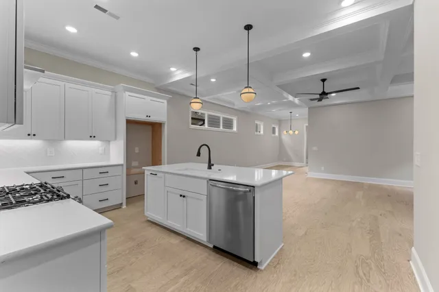 a kitchen with granite countertop a stove top oven a sink and dishwasher