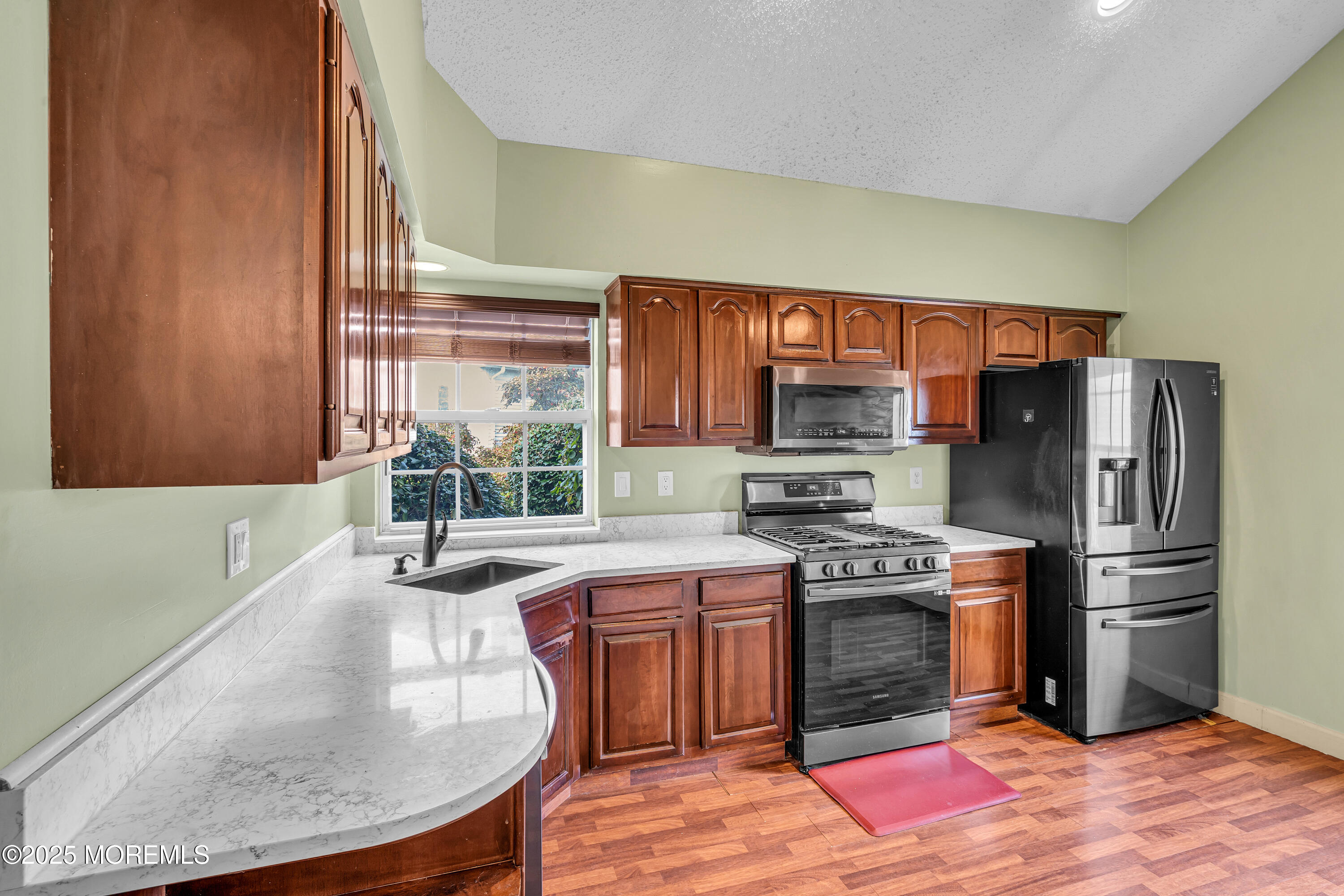 57 Racquet Road Wall, NJ 07719 - Photo 8 of 33 a kitchen with a stove a sink and a refrigerator
