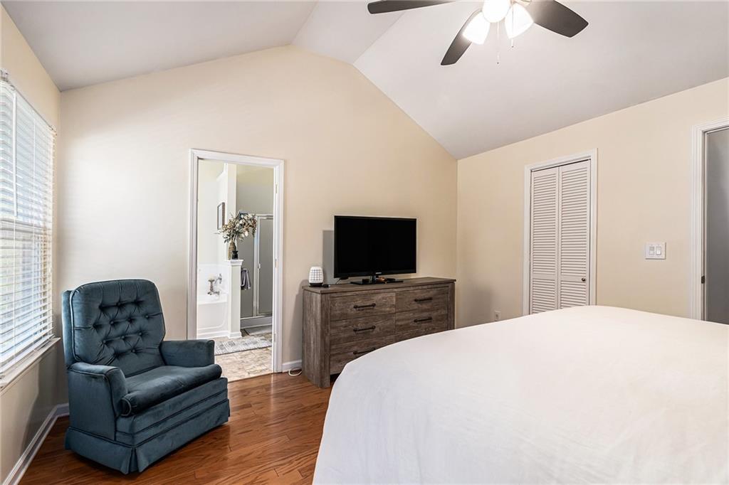 1111 Watercourse Way Hampton, GA 30228 - Photo 18 of 30 a bedroom with a bed couch and a flat screen tv