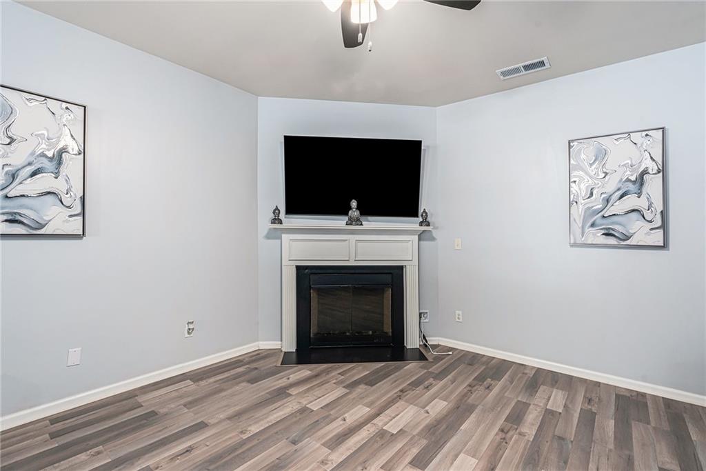 1111 Watercourse Way Hampton, GA 30228 - Photo 6 of 30 a living room with a fireplace and a flat screen tv