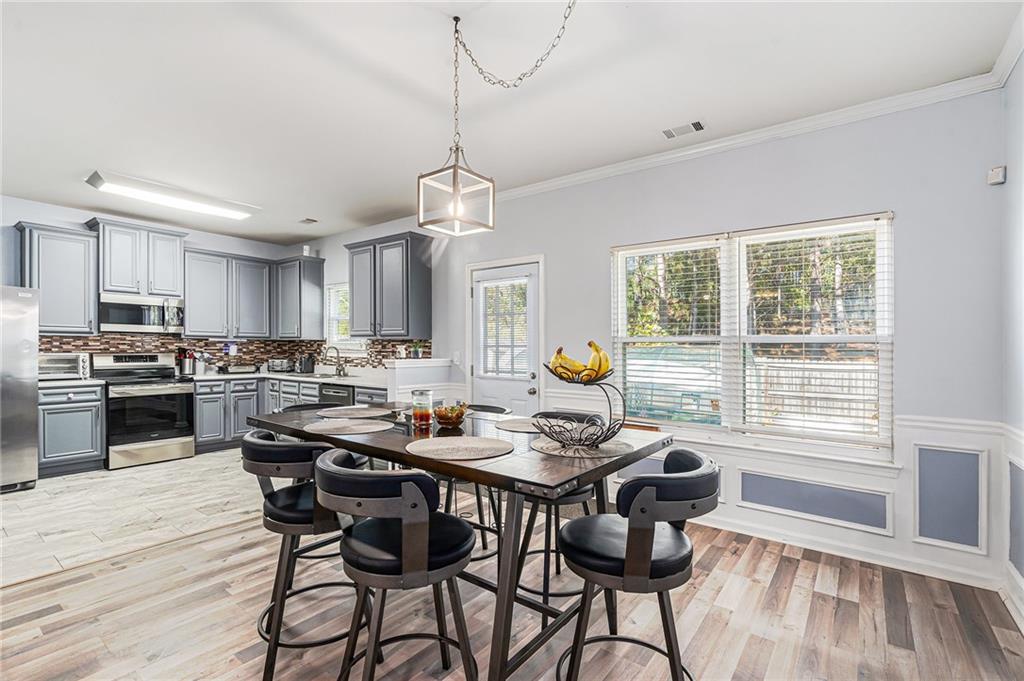 1111 Watercourse Way Hampton, GA 30228 - Photo 9 of 30 a view of a dining room with furniture wooden floor and chandelier