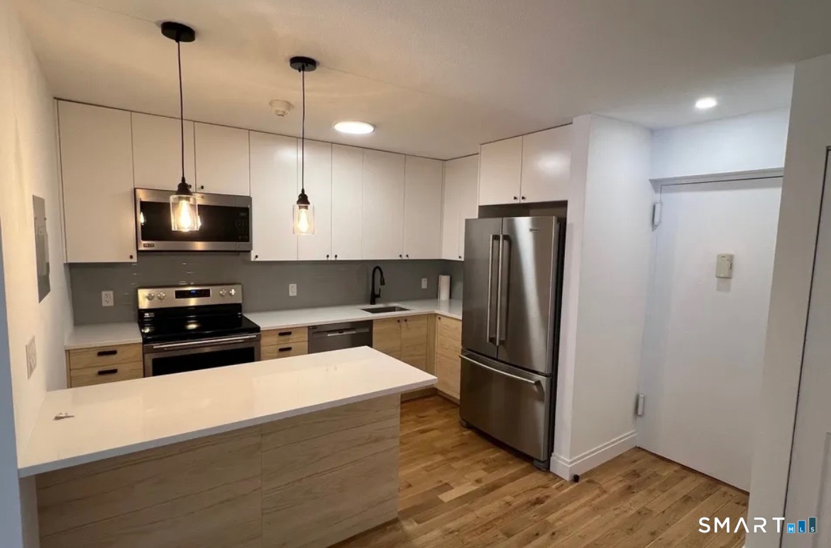 67 Balance Rock Road, Unit 7 Seymour, CT 06483 - Photo 4 of 12 a kitchen with refrigerator a microwave and wooden floor