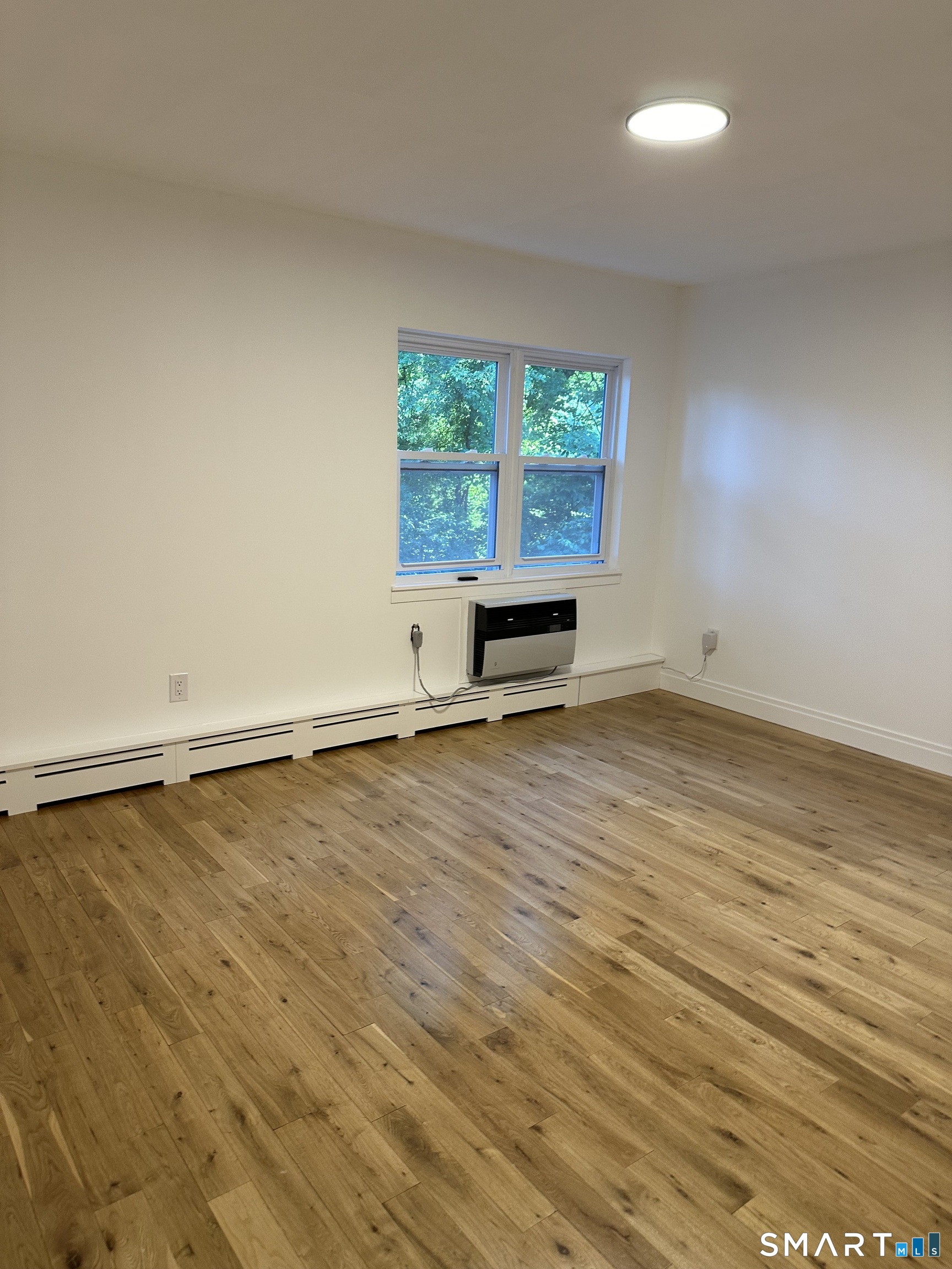 67 Balance Rock Road, Unit 7 Seymour, CT 06483 - Photo 9 of 12 an empty room with wooden floor and windows