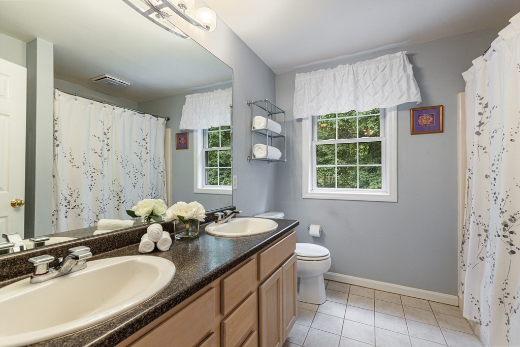 2 Gerald Avenue Millis, MA 02054 - Photo 30 of 38 a bathroom with a granite countertop sink a large mirror a toilet and a shower