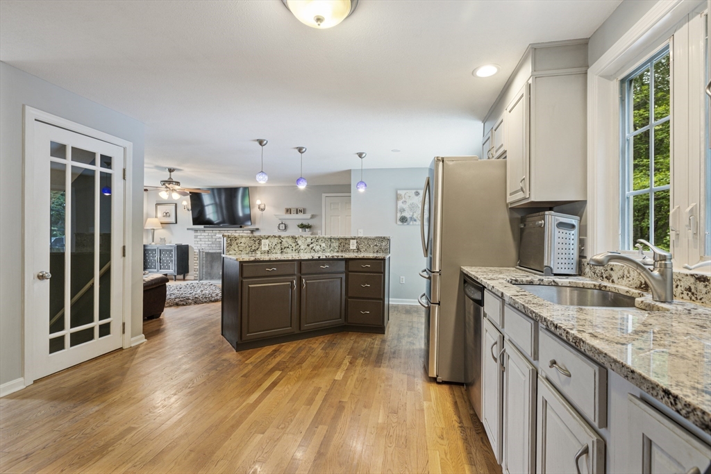 2 Gerald Avenue Millis, MA 02054 - Photo 8 of 38 a kitchen with stainless steel appliances kitchen island granite countertop a refrigerator a sink dishwasher a stove with wooden cabinets and floor