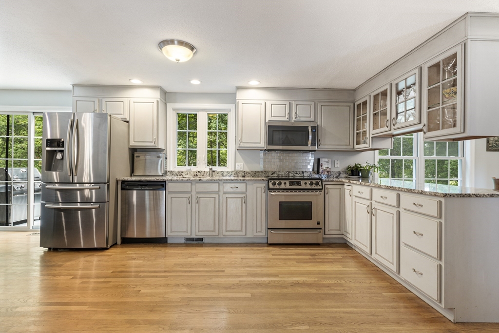 2 Gerald Avenue Millis, MA 02054 - Photo 9 of 38 a kitchen with stainless steel appliances granite countertop a stove top oven a sink dishwasher a refrigerator and cabinets with wooden floor