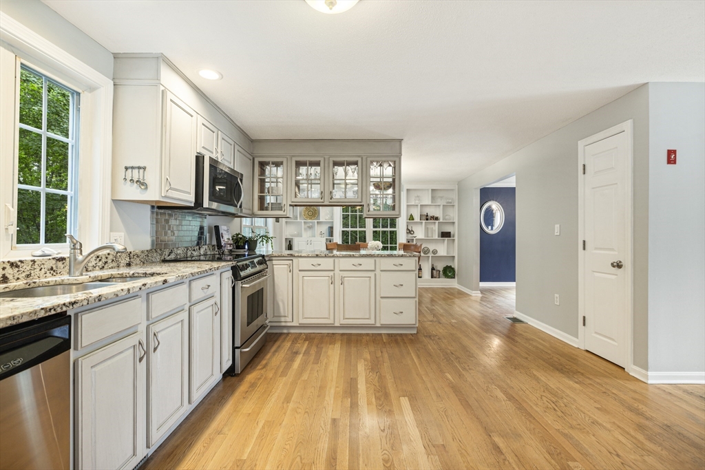2 Gerald Avenue Millis, MA 02054 - Photo 10 of 38 a kitchen with stainless steel appliances a white stove top oven a sink dishwasher and a refrigerator with wooden floor