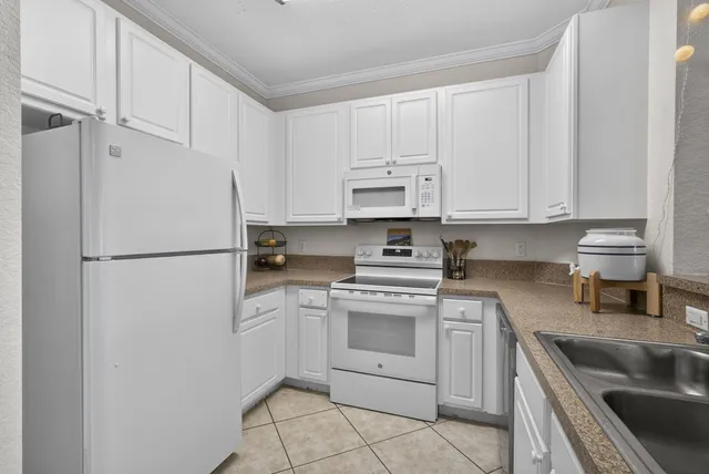 a kitchen with white cabinets and white appliances