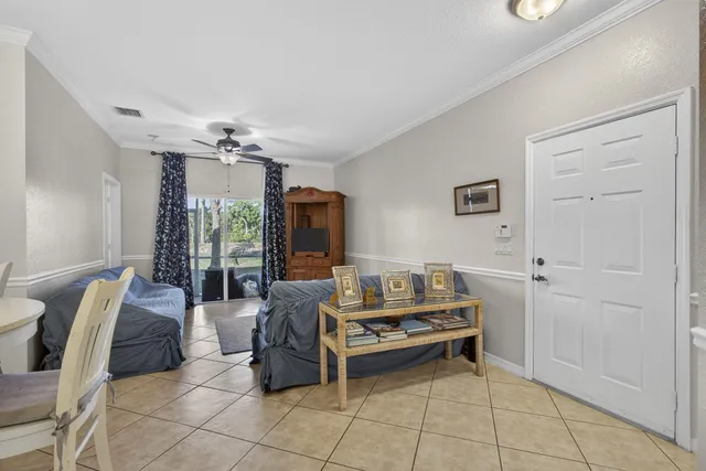 a living room with furniture a chandelier and a dining table
