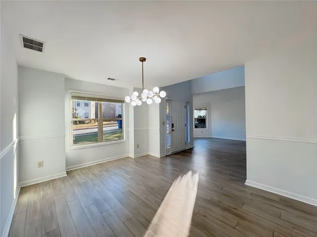 a view of empty room with fireplace and wooden floor
