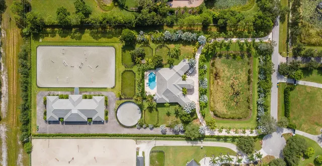 an aerial view of a house with a garden and trees all around