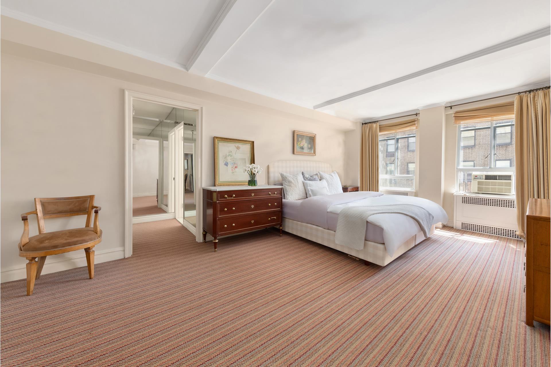 19 East 88th Street, Unit 9C Manhattan, NY 10128 - Photo 5 of 9 a bedroom with a bed and a chair