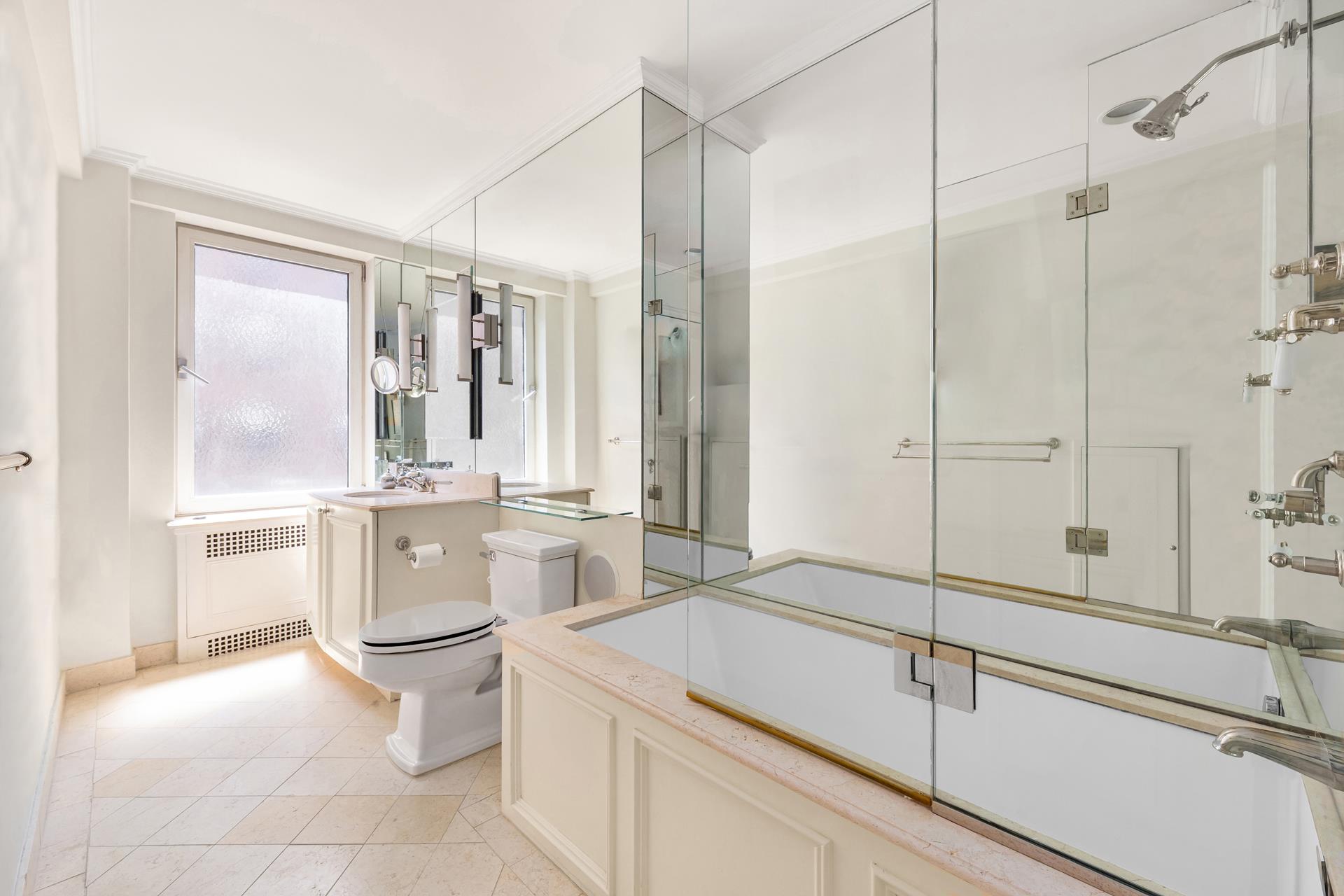 19 East 88th Street, Unit 9C Manhattan, NY 10128 - Photo 6 of 9 a bathroom with a double vanity sink a toilet and shower