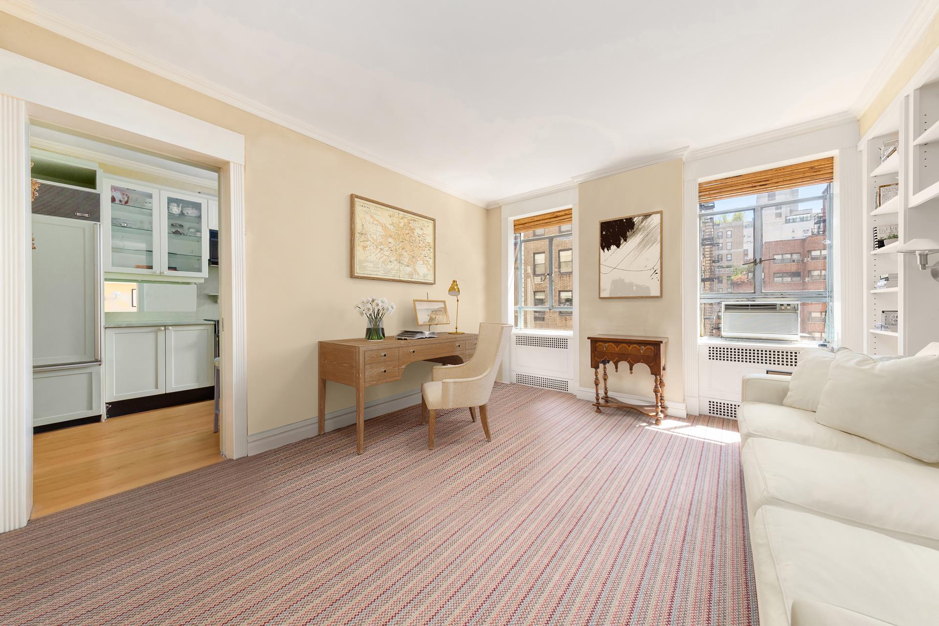 19 East 88th Street, Unit 9C Manhattan, NY 10128 - Photo 7 of 9 a living room with furniture a fireplace and a window