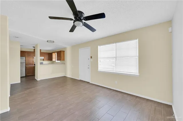 a view of a livingroom with a ceiling fan & windows