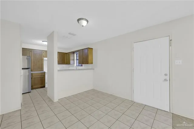 a view of a kitchen with refrigerator and white cabinets