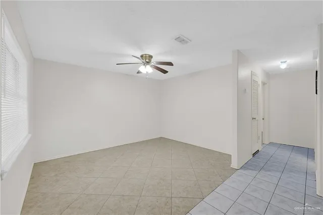 an empty room with chandelier fan