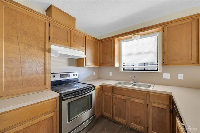 a kitchen with a sink stove top oven and cabinets