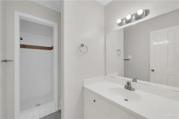 a bathroom with a sink a shower and a mirror