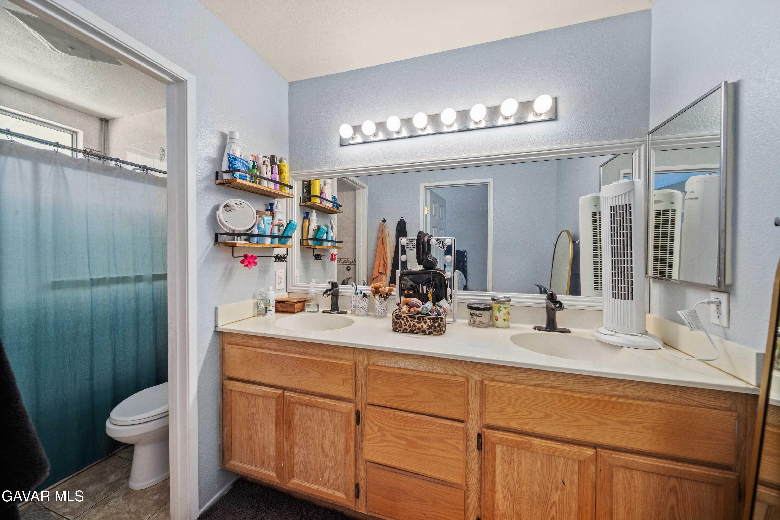 45736 Victoria Avenue Lancaster, CA 93534 - Photo 25 of 30 a bathroom with a sink a toilet and a mirror