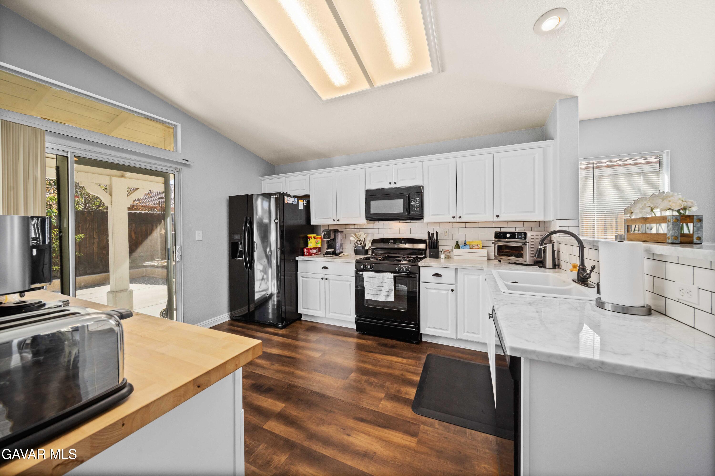 45736 Victoria Avenue Lancaster, CA 93534 - Photo 10 of 30 a kitchen with granite countertop a refrigerator stove and sink