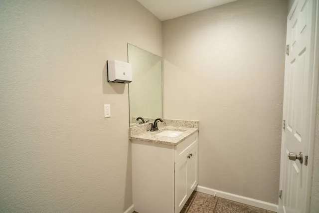 a bathroom with a sink and mirror with toilet