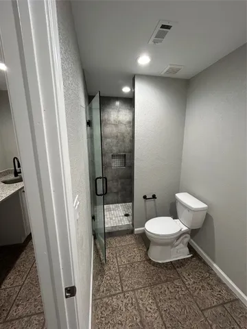 a bathroom with a toilet and a shower
