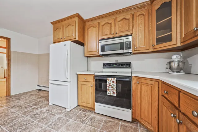 a kitchen with stainless steel appliances granite countertop a refrigerator and a stove top oven