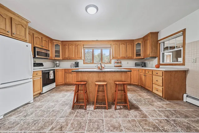 a kitchen with stainless steel appliances granite countertop a stove a sink a microwave and a refrigerator