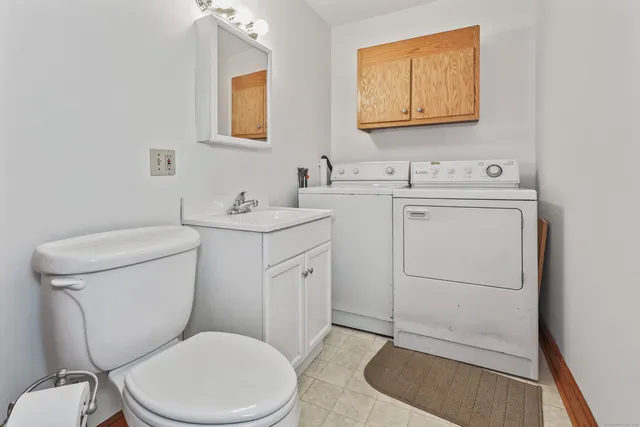 a bathroom with a toilet a sink and mirror