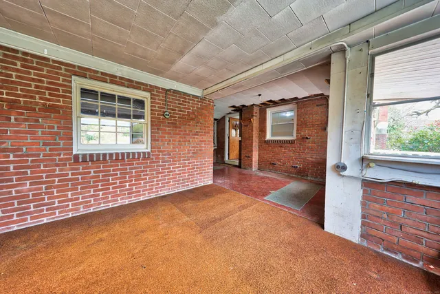 a view of an empty room with a fireplace and a window