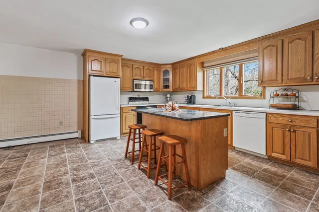 a kitchen with stainless steel appliances granite countertop a stove a sink a microwave and a refrigerator