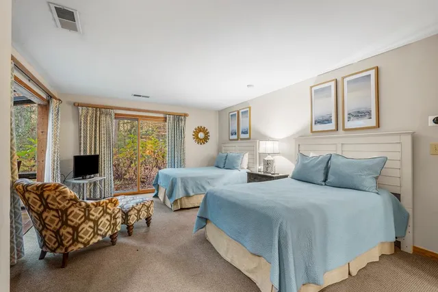 a view of a patio with couches table and chairs under an umbrella