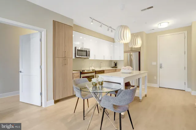a kitchen with a table chairs refrigerator and microwave