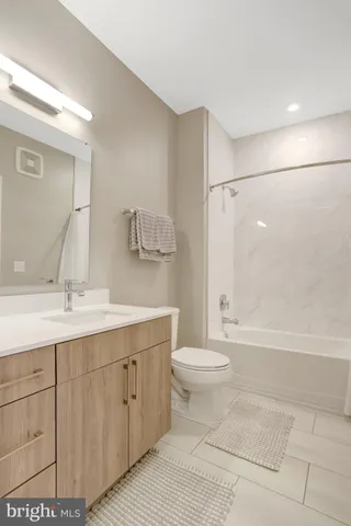 a bathroom with a double vanity sink toilet mirror and bathtub