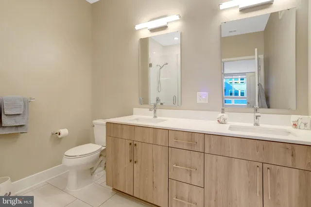 a bathroom with a double vanity sink toilet and a mirror