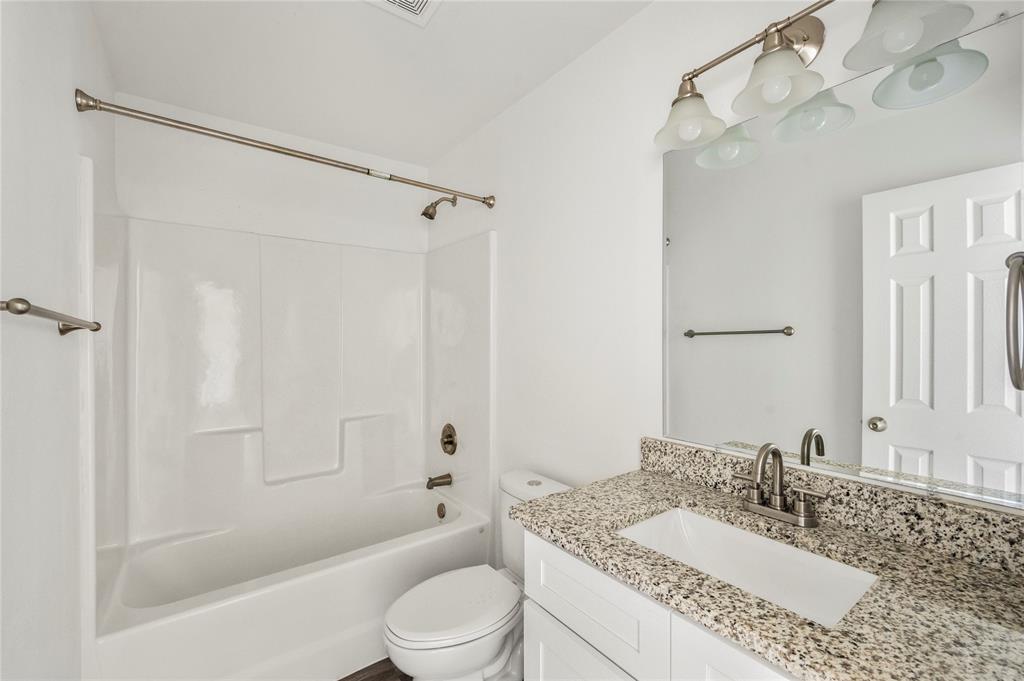 437 Whitney Court Rio Vista, TX 76093 - Photo 12 of 21 a bathroom with a granite countertop sink toilet mirror and shower