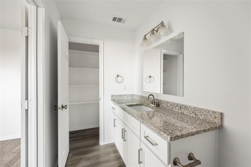 437 Whitney Court Rio Vista, TX 76093 - Photo 18 of 21 a bathroom with a granite countertop sink and a mirror