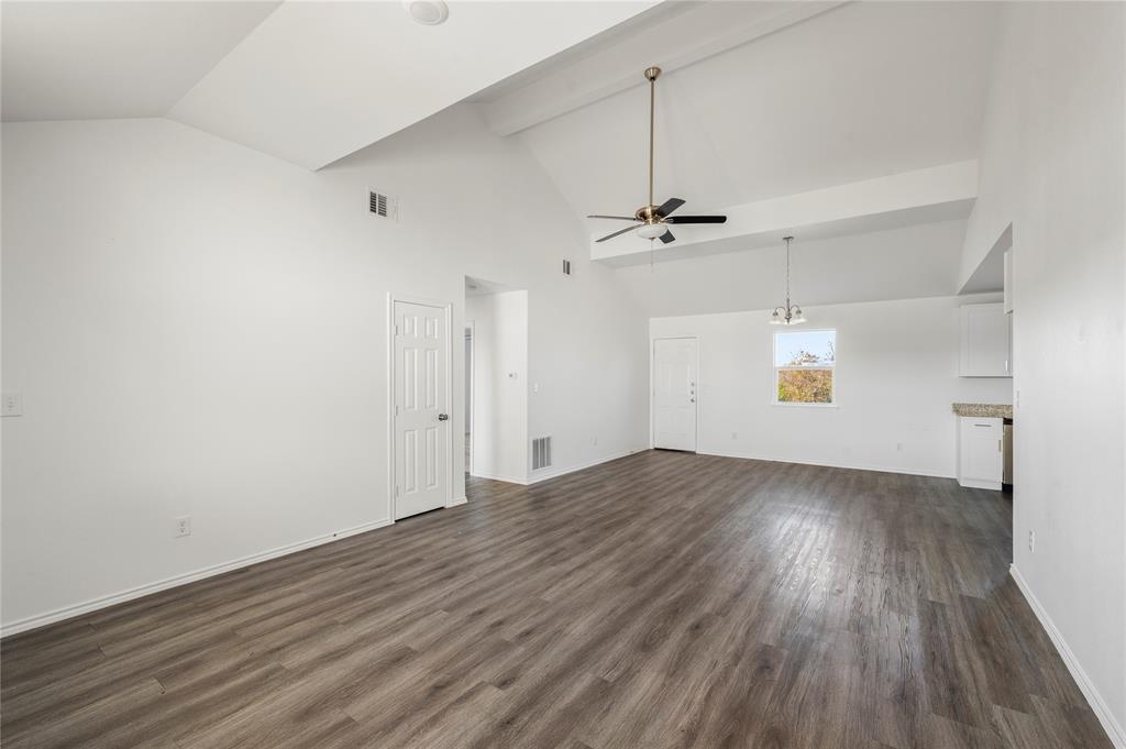 437 Whitney Court Rio Vista, TX 76093 - Photo 2 of 21 an empty room with wooden floor a ceiling fan and windows