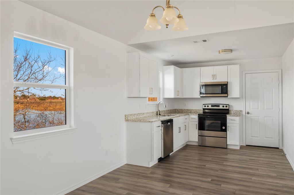 437 Whitney Court Rio Vista, TX 76093 - Photo 6 of 21 a kitchen with stainless steel appliances a white stove top oven and a refrigerator