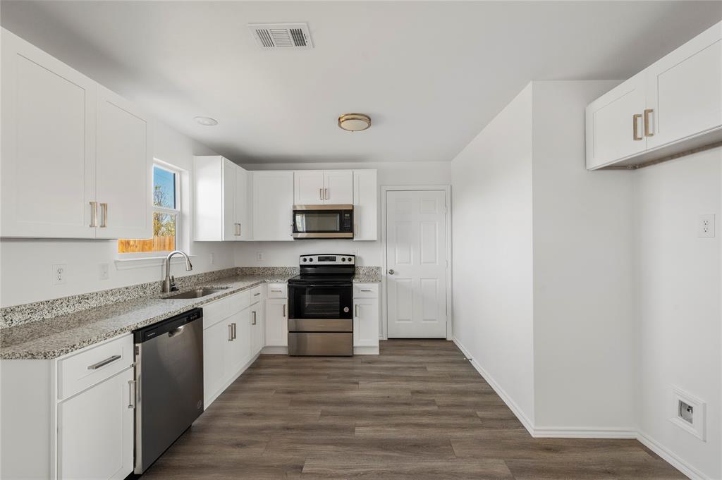 437 Whitney Court Rio Vista, TX 76093 - Photo 7 of 21 a kitchen with stainless steel appliances granite countertop a stove a sink and a refrigerator